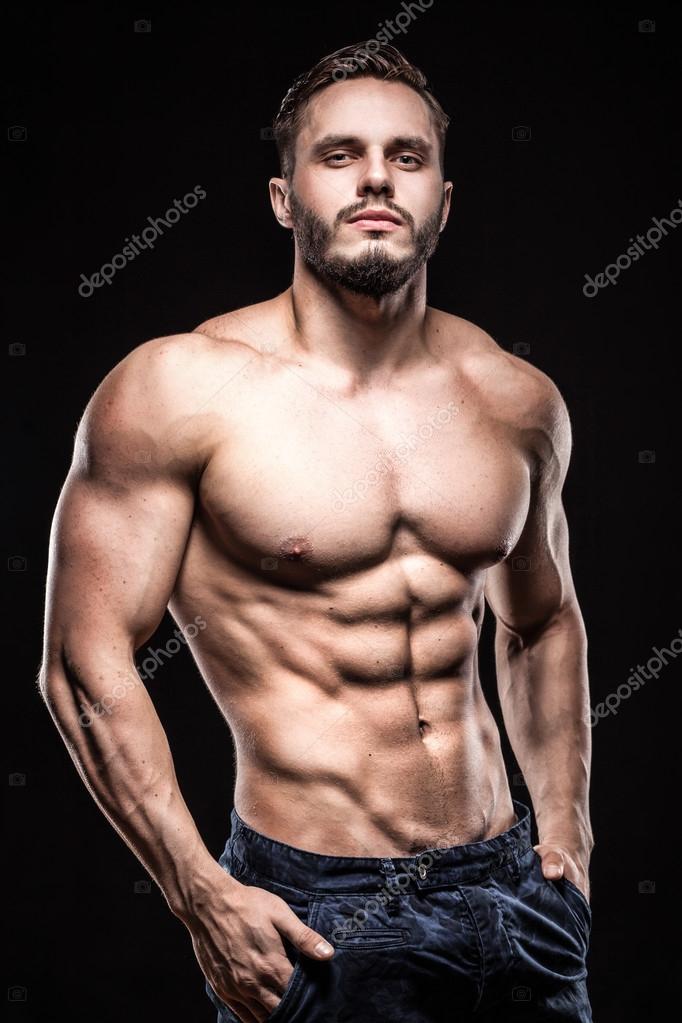 Attractive bodybuilder sportsman shows perfect body muscles on b Stock