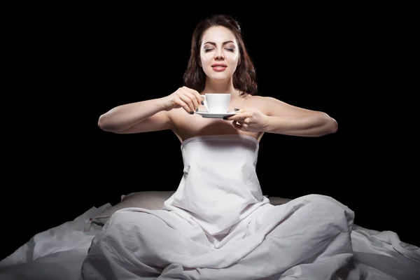 Giovane donna seduta a letto e bere caffè ; — Foto Stock