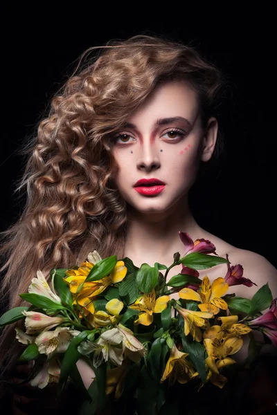 年轻的金发女孩在黑色背景上养花 — 图库照片