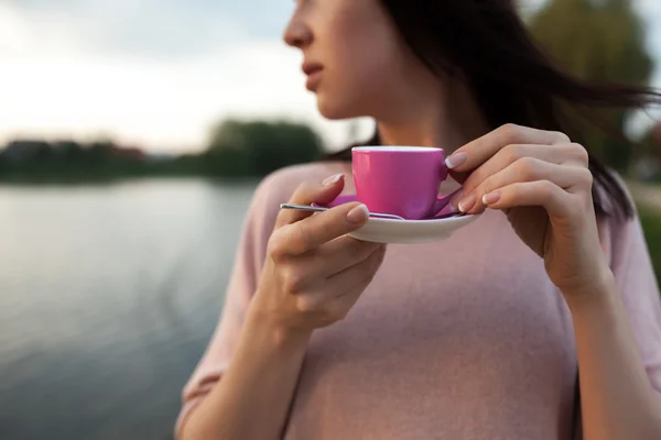 Female near lake or river and keeps cup of coffee; — Stock Photo, Image