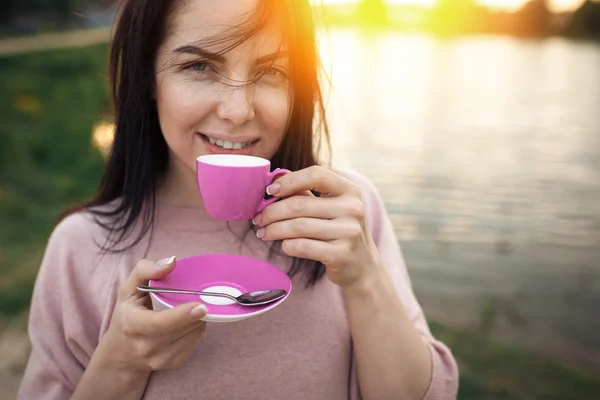 Femmina vicino lago o fiume e mantiene tazza di caffè ; — Foto Stock