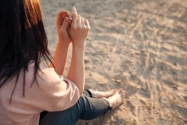 Femmina scalza seduta su sabbia in raggi di sole ; — Foto Stock