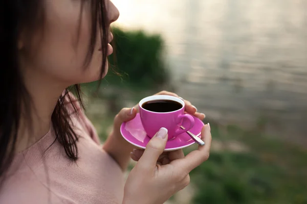 Femmina tenere tazza di caffè vicino lago o fiume ; — Foto Stock