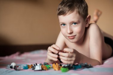 Küçük çocuk oyuncaklarla oynuyor.;