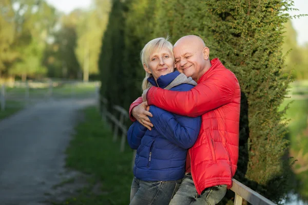 Feliz pareja de ancianos abrazar y sonreír ; — Foto de Stock