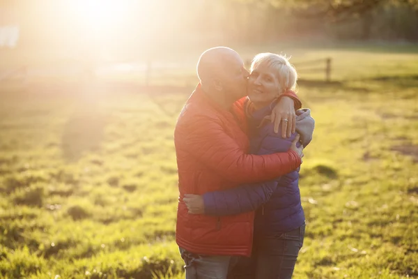 Feliz pareja de ancianos abrazar y sonreír ; — Foto de Stock