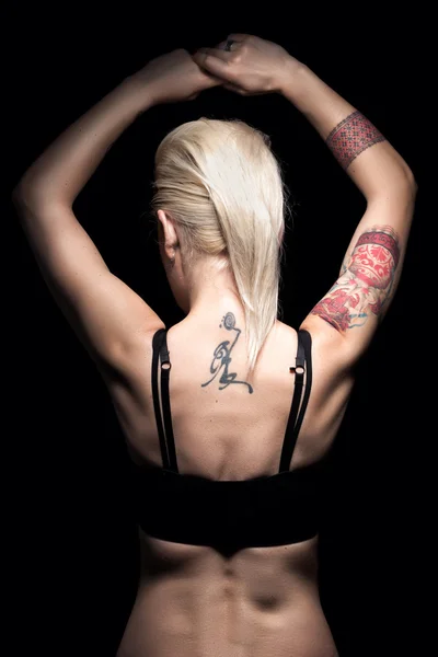 Baksidan av punk blond kvinna med tatuering och piercing och kort frisyr — Stockfoto