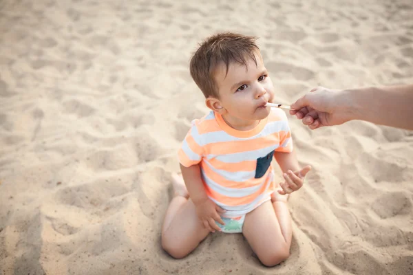 Little boy eat icecream from mothers hand; — Stock Photo, Image