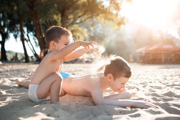 Маленькие дети играют с песком на пляже ; — стоковое фото