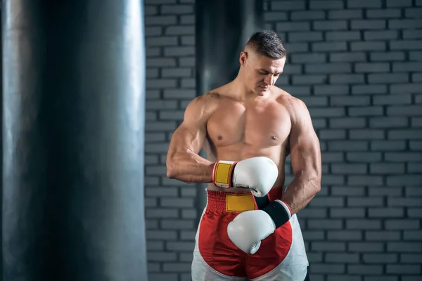 Silný sportovec boxer cvičení v bílých rukavicích v posilovně — Stock fotografie