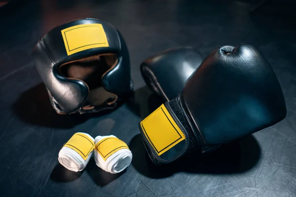 Vista superior de guantes de boxeo, casco y cinta adhesiva sobre fondo negro —  Fotos de Stock