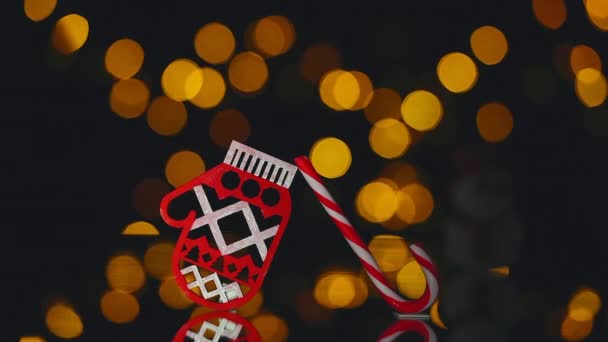 Close up of decorative christmas toy, mitten and candy cane with blurred lights — Stock Video