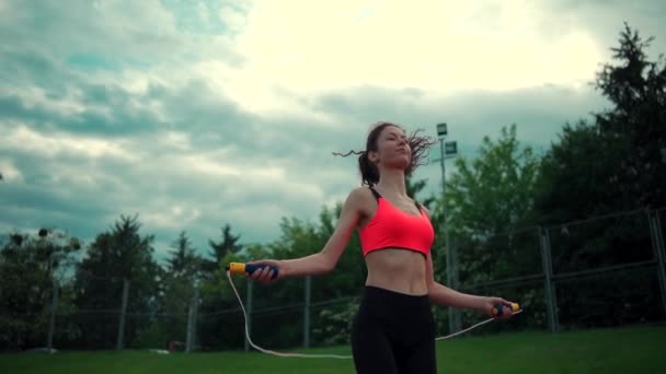 Atletic de sex feminin antrenament și sărituri cu sari peste frânghie în aer liber în ziua însorită — Videoclip de stoc