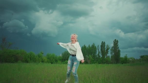 陽気な年配の女性が曇り空で踊り回り — ストック動画