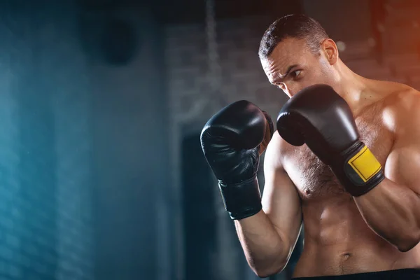 Primer plano de entrenamiento masculino boxeador muscular y entrenamiento con saco de boxeo en el gimnasio —  Fotos de Stock