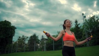 Atletik kadın sporu ve atlama güneşli bir günde ip atlama.