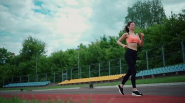 Atletik kadın yazın dışarıda koşuyor ve antrenman yapıyor.