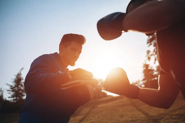 Sporcu boksör boksör boks eldivenleriyle dışarıda antrenörlük yapıyor. — Stok fotoğraf