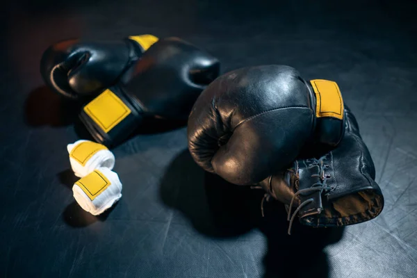 Guantes de boxeo, casco y cinta adhesiva sobre fondo negro —  Fotos de Stock