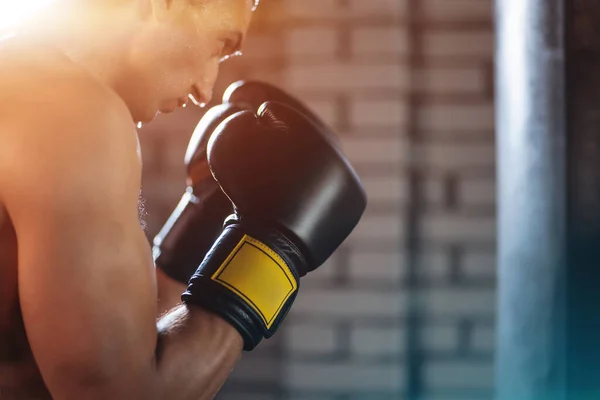 Primer plano de entrenamiento masculino boxeador muscular y entrenamiento con saco de boxeo en el gimnasio —  Fotos de Stock