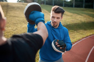 Spor adam boks yapıyor ve spor eldivenleriyle spor yapıyor.