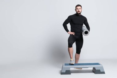 Spor adamı ya da vücut geliştirme ekipmanı ve beyaz arka planda yoga minderi.