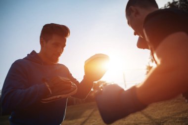 Sporcu boksör boksör boks eldivenleriyle dışarıda antrenörlük yapıyor.