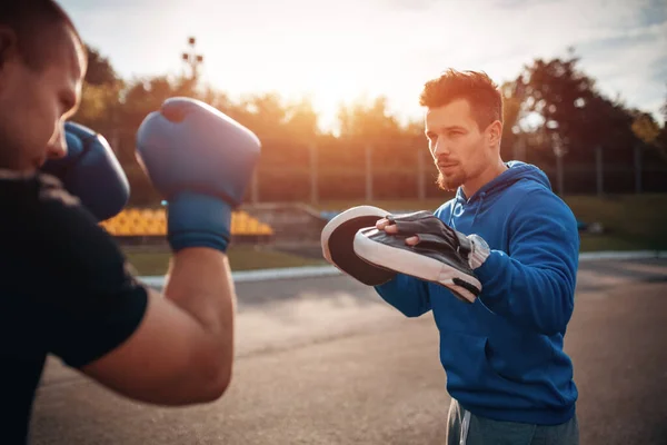 Sporcu boksör boksör boks eldivenleriyle dışarıda antrenörlük yapıyor. — Stok fotoğraf