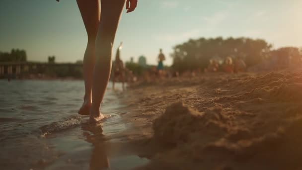 Closeup of woman legs walking on sea beach bare foot after swimming at sunset — Stock Video
