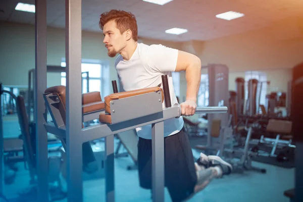 Joven atlético masculino tiene entrenamiento personal y tire hacia arriba en el bar en el gimnasio — Foto de Stock