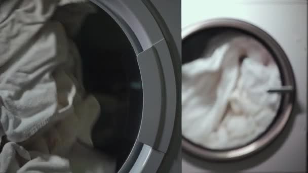 Close-up beddengoed en handdoeken en kleding drogen in industriële droger machine — Stockvideo