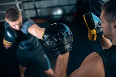 İki kas boksörü spor adamı antrenmanı ve boks ringinde dövüşüyor.