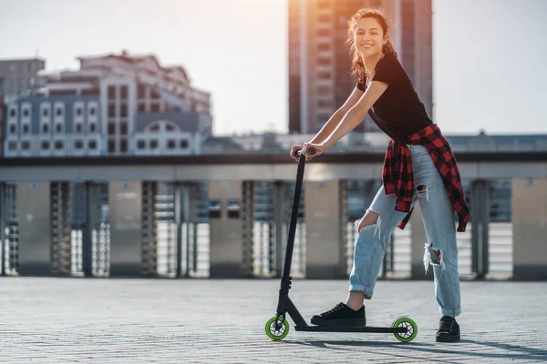 Jovem adolescente em sapatilha no moderno extremo dublê chutar scooter na cidade — Fotografia de Stock