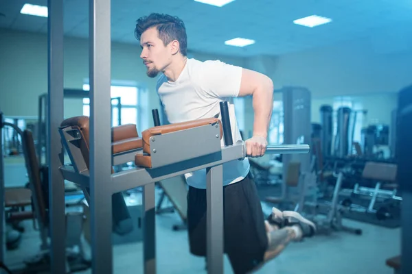 Genç atletik erkek kişisel antrenman yapıyor ve spor salonunda barın önüne park ediyor. — Stok fotoğraf