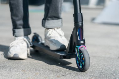 Genç spor ayakkabılı modern ekstrem dublör tekme scooter 'ı ile kaykay parkında