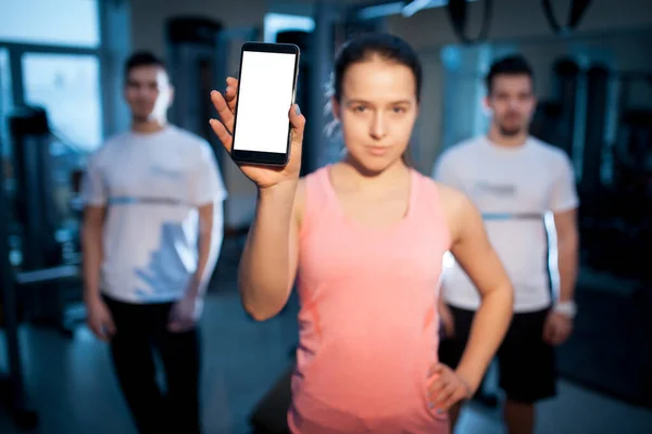 Personas de fitness en el gimnasio tienen entrenamiento en línea o ejercicio con el teléfono inteligente — Foto de Stock