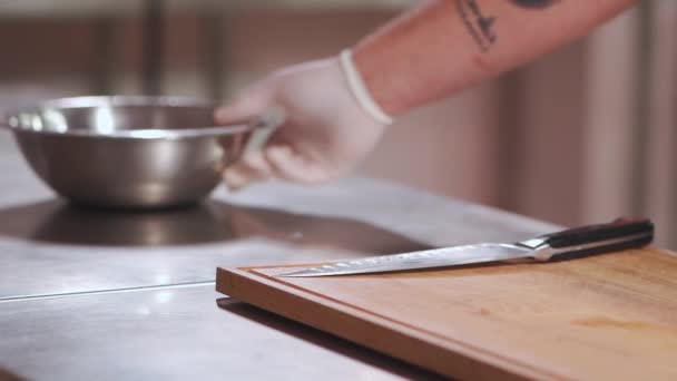 シェフは医療用手袋で手を調理スチールボウルに新鮮なギリシャのサラダを準備 — ストック動画