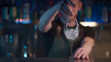 Gece kulübünde aperol spritz kokteyli için buz karıştıran barmen.