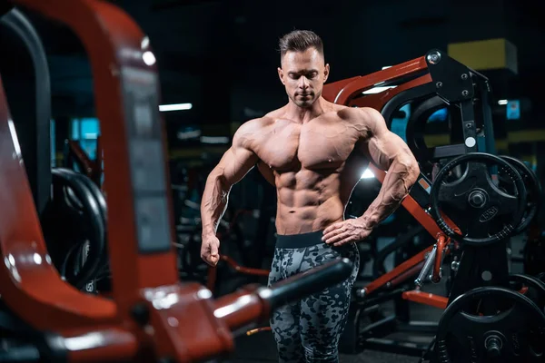 Young athletic sportsman bodybuilder with muscle perfect body posing in gym — Stock Photo, Image