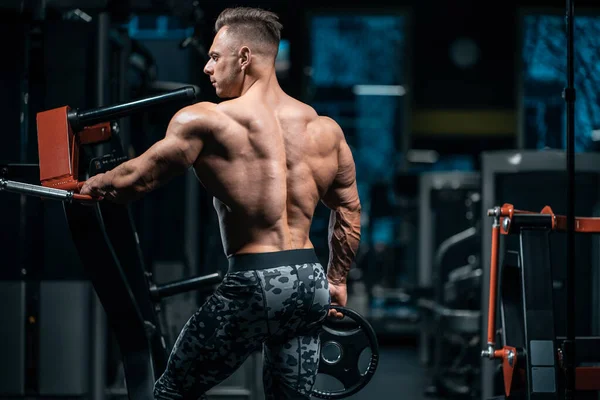 Young sportsman bodybuilder with muscle body in gym — Stock Photo, Image