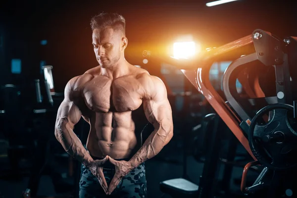 Joven deportista atlético culturista con músculo cuerpo perfecto posando en el gimnasio —  Fotos de Stock