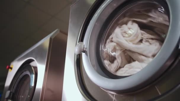 Washing machine and dryer working at professional industrial laundry, slow mo — Stock Video