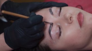 Güzellik salonundaki kadın kaşlarını kınayla boyayın.