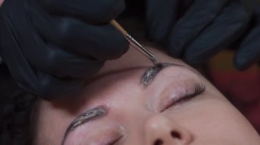 Güzellik salonundaki kadın kaşlarını kınayla boyayın.