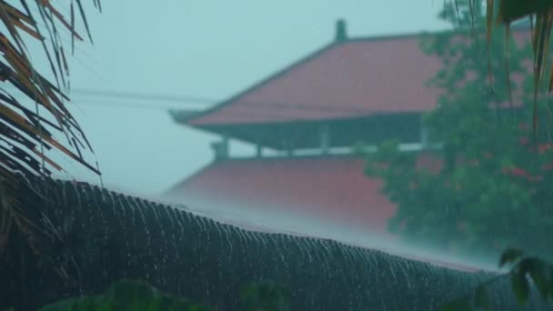 Αργή κίνηση της ασιατικής τροπικής βροχής με το ναό στο παρασκήνιο — Αρχείο Βίντεο
