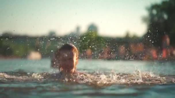 Aktywne młode dziecko pływać w jeziorze, rzece lub morzu i grać wody splash na wakacjach — Wideo stockowe