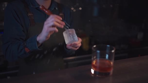 Bartender preparing traditional old fashioned cocktail with whiskey and orange — Stock Video