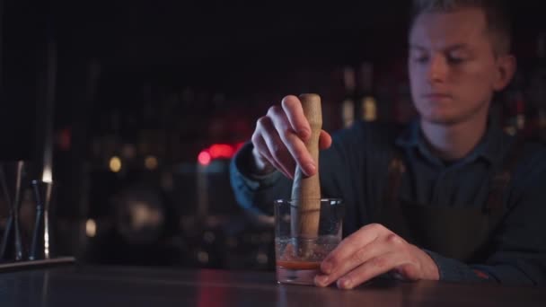 Bartender preparing traditional old fashioned cocktail with whiskey and orange — Stock Video