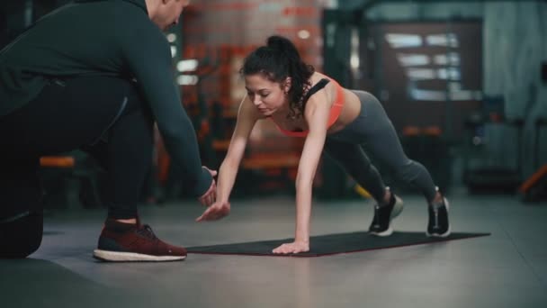 Личный тренер с фитнес-женщина упражнения в тренажерном зале — стоковое видео
