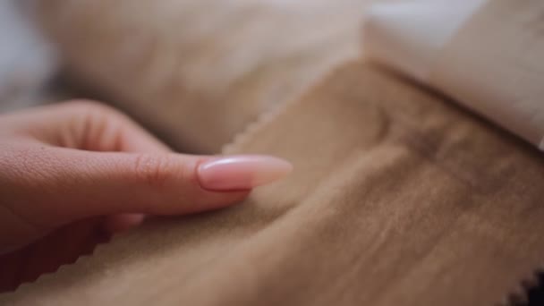 Primer plano de las manos femeninas elegir tela para cortina en sala de exposición textil — Vídeos de Stock